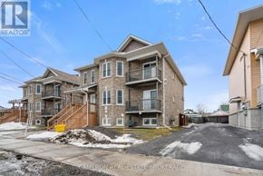 Cornwall triplex for rent - A large apartment complex with a clear blue sky above.