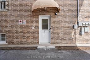 Cornwall triplex for rent - A brick building with a white door and a no parking sign on the wall.