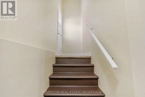 Cornwall triplex for rent - A staircase with a white handrail and brown steps.