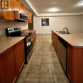 Barrie (Edgehill Drive) apartment for rent - A kitchen with brown cabinets and black appliances.