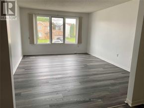 Cobourg townhouse for rent - A room with a window showing a view of a residential area.