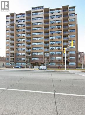 Hamilton condo for rent - A tall apartment building with a sign that says REALTOR.