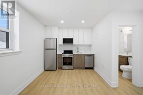 Toronto (O'connor-Parkview) multi-family for rent - A kitchen with white walls and wooden floors.