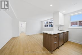 Toronto (O'connor-Parkview) multi-family for rent - A spacious room with wooden flooring and a kitchenette area.