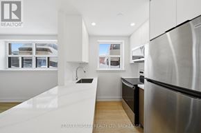 Toronto (O'connor-Parkview) multi-family for rent - A modern kitchen with stainless steel appliances and white cabinetry.