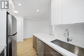 Toronto (O'connor-Parkview) multi-family for rent - A modern kitchen with white cabinets and a stainless steel refrigerator.