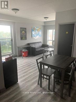 Waterloo condo for rent - A living room with a couch, a table and chairs.