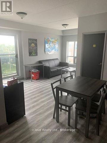 Waterloo condo for rent - A living room with a couch, a table and chairs.