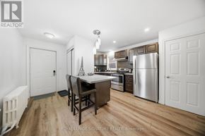 Hamilton (Corktown) triplex for rent - A well-lit kitchen with a dining table and chairs.