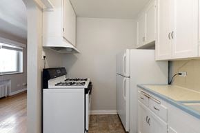 Denver apartment for rent - an empty kitchen with white appliances and white cabinets