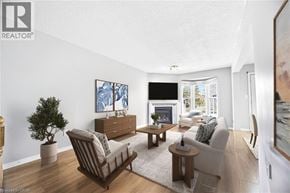 Stoney Creek townhouse for rent - A living room with a fireplace and a painting on the wall.
