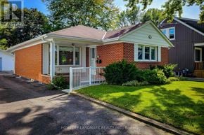 St. Catharines (Port Dalhousie) apartment for rent - A red brick house with a white fence in front.