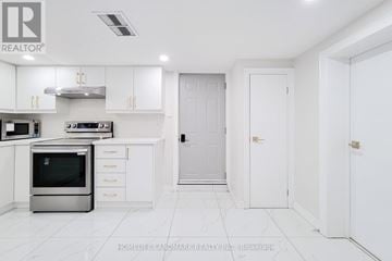 St. Catharines (Port Dalhousie) apartment for rent - A white kitchen with a stainless steel oven and white cabinets.