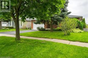 Kitchener apartment for rent - A tree in front of a house with a sign that says REALTOR.