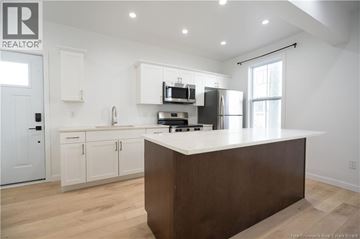 Saint John apartment for rent - A modern kitchen with white cabinets and a wooden island.