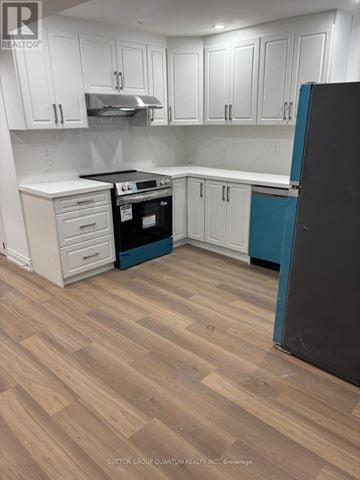 Brampton (Bram East) apartment for rent - A kitchen with white cabinets and a black refrigerator.