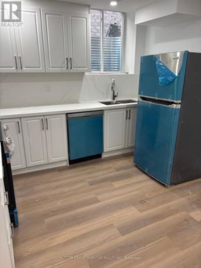 Brampton (Bram East) apartment for rent - A kitchen with a blue refrigerator and white cabinets.