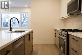 Calgary apartment for rent - A kitchen with a sink, stove, and cabinets.