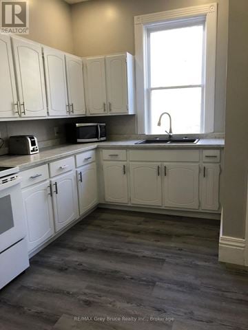 Arran-Elderslie apartment for rent - A kitchen with white cabinets and a window.