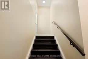 Cornwall triplex for rent - A staircase with a metal handrail and wooden steps.