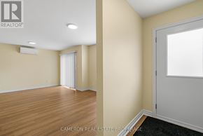 Cornwall triplex for rent - A room with wooden flooring and a sliding door.