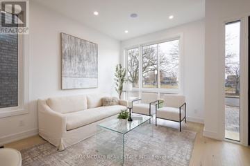 Toronto (New Toronto) apartment for rent - A living room with a white couch, a glass coffee table, and a painting on the wall.