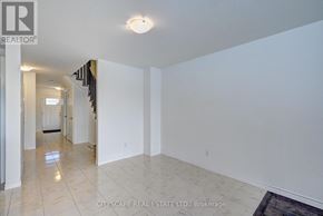 Kitchener townhouse for rent - A long hallway with a door on the left and a table with chairs on the right.
