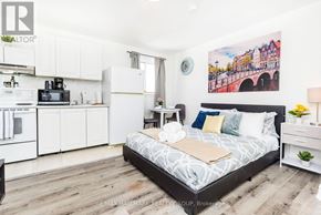 Ottawa apartment for rent - A bedroom with a bed, nightstand, and a painting on the wall.
