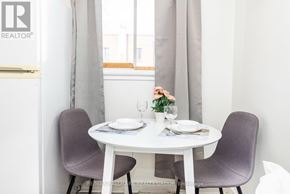 Ottawa apartment for rent - A dining table with two chairs and a vase with flowers on it.