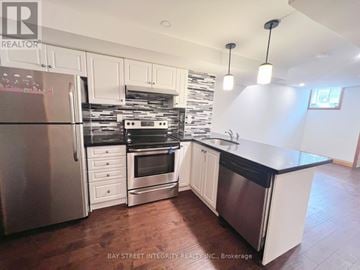 Oakville (Go Glenorchy) apartment for rent - A kitchen with white cabinets and a black countertop.