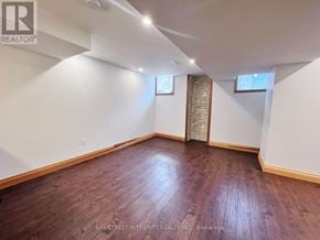 Oakville (Go Glenorchy) apartment for rent - A room with wooden flooring and white walls, with a window and a door visible.