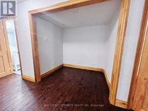 Oakville (Go Glenorchy) apartment for rent - A room with wooden floors and white walls, with a doorway leading to another room.
