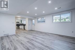 Welland (West Welland) apartment for rent - A spacious room with a grey floor and white walls.