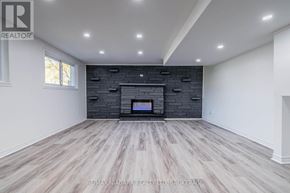 Welland (West Welland) apartment for rent - A spacious room with a fireplace and wood flooring.