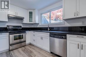 Welland (West Welland) apartment for rent - A kitchen with white cabinets and black countertops.