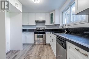 Welland (West Welland) apartment for rent - A modern kitchen with white cabinets and a black countertop.