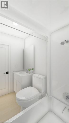 Guelph townhouse for rent - A white bathroom with a toilet, sink, and mirror.