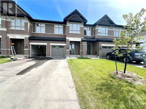 Ottawa townhouse for rent - A large, modern house with a driveway and a tree in the front yard.