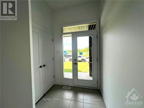 Ottawa townhouse for rent - A white door with a glass window is open, revealing a parking lot outside.