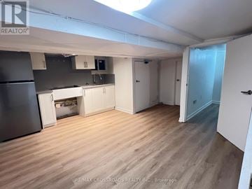 Toronto (South Riverdale) apartment for rent - A kitchen area with a refrigerator, cabinets, and a microwave.