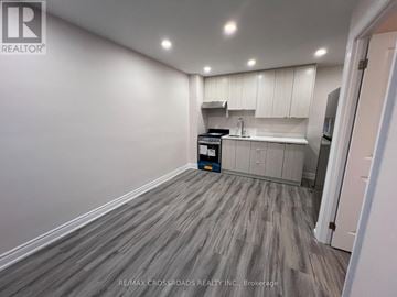 Toronto (Greenwood-Coxwell) apartment for rent - A kitchen area with a white cabinet and a grey floor.