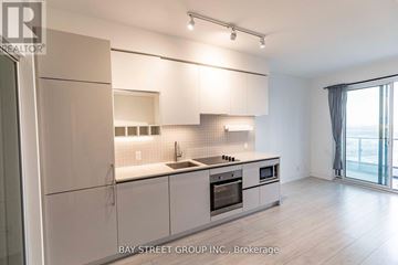 Vaughan (Vaughan Corporate Centre) condo for rent - A modern kitchen with white cabinets and a large window.