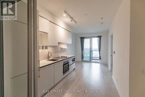 Vaughan (Vaughan Corporate Centre) condo for rent - A modern kitchen with white cabinets and a large window.