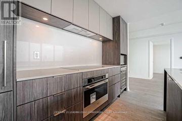 Toronto (Mimico) condo for rent - A modern kitchen with dark wood cabinets and a stainless steel oven.