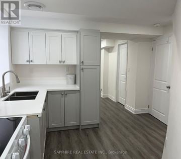 Thorold (Rolling Meadows) apartment for rent - A kitchen with white cabinets and a grey countertop.
