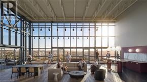 Kitchener condo for rent - A group of people are gathered in a large room with a view of the city.