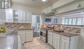 Newmarket (Central Newmarket) apartment for rent - A kitchen with white cabinets and a stone backsplash.