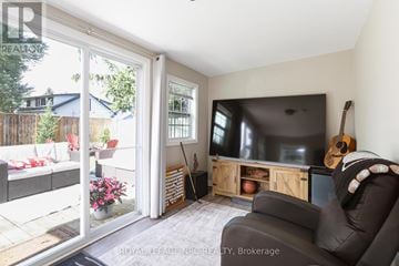 Fort Erie (Crystal Beach) apartment for rent - A living room with a television and a guitar on the wall.