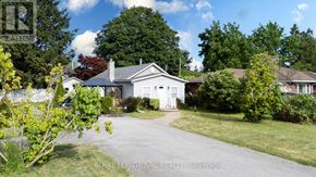 Fort Erie (Crystal Beach) apartment for rent - A white house with a grey roof is surrounded by greenery.