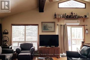 Blue Mountains apartment for rent - A living room with a black leather couch and a flat screen TV.